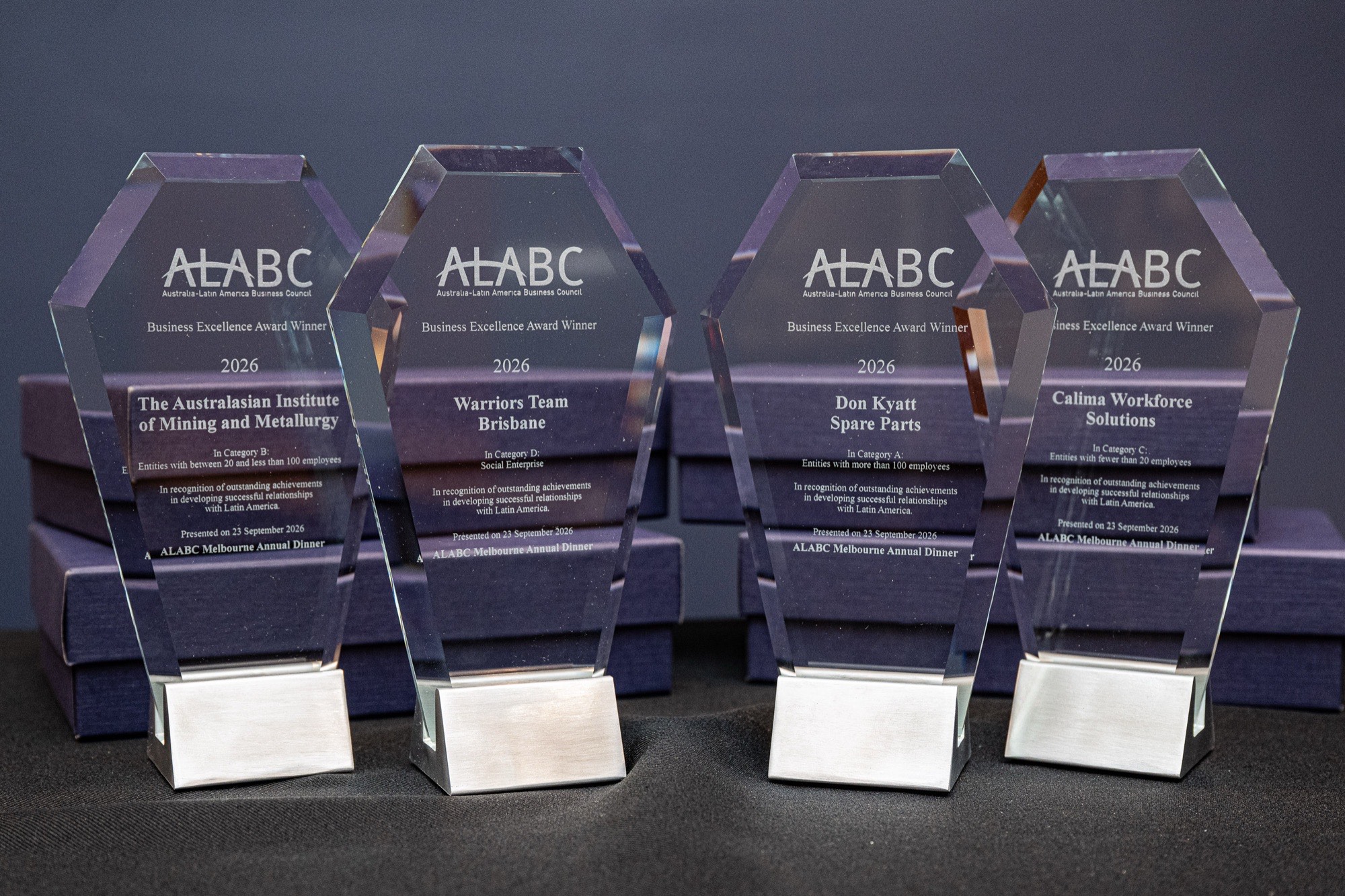 The four 2026 trophies lined up, with the Warriors Team Brisbane engraving legible