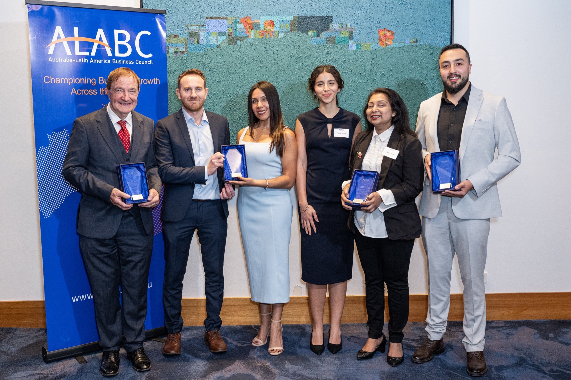All four 2026 Business Excellence Award winners holding their trophies in front of the ALABC banner
